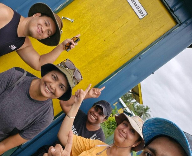 Group of people standing infront of a home they built.